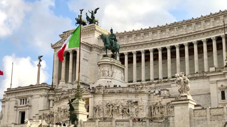 The Vittoriano Monument in Rome, Italy, featuring grand architecture and the Italian flag.